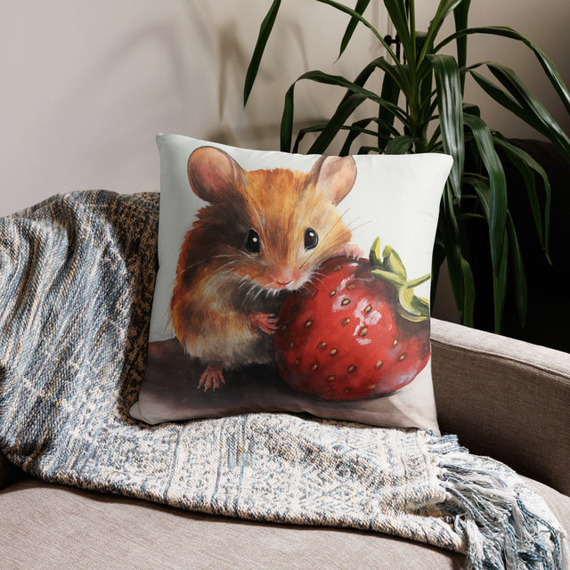 Mouseberry - Pillow featuring a detailed fantasy art design of a small mouse holding a large ripe strawberry, placed on a cozy couch with a textured blanket and green plant background.