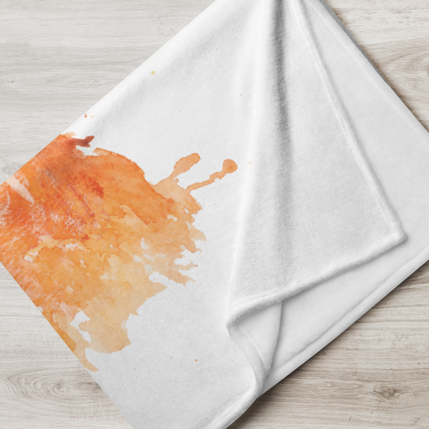 Autumn Owl - Blanket white fabric with orange owl fantasy art on a light wood surface, folded.