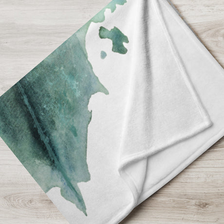 Dragonheart - Blanket folded on light wood with teal dragon silhouette, fantasy art theme on soft white fabric