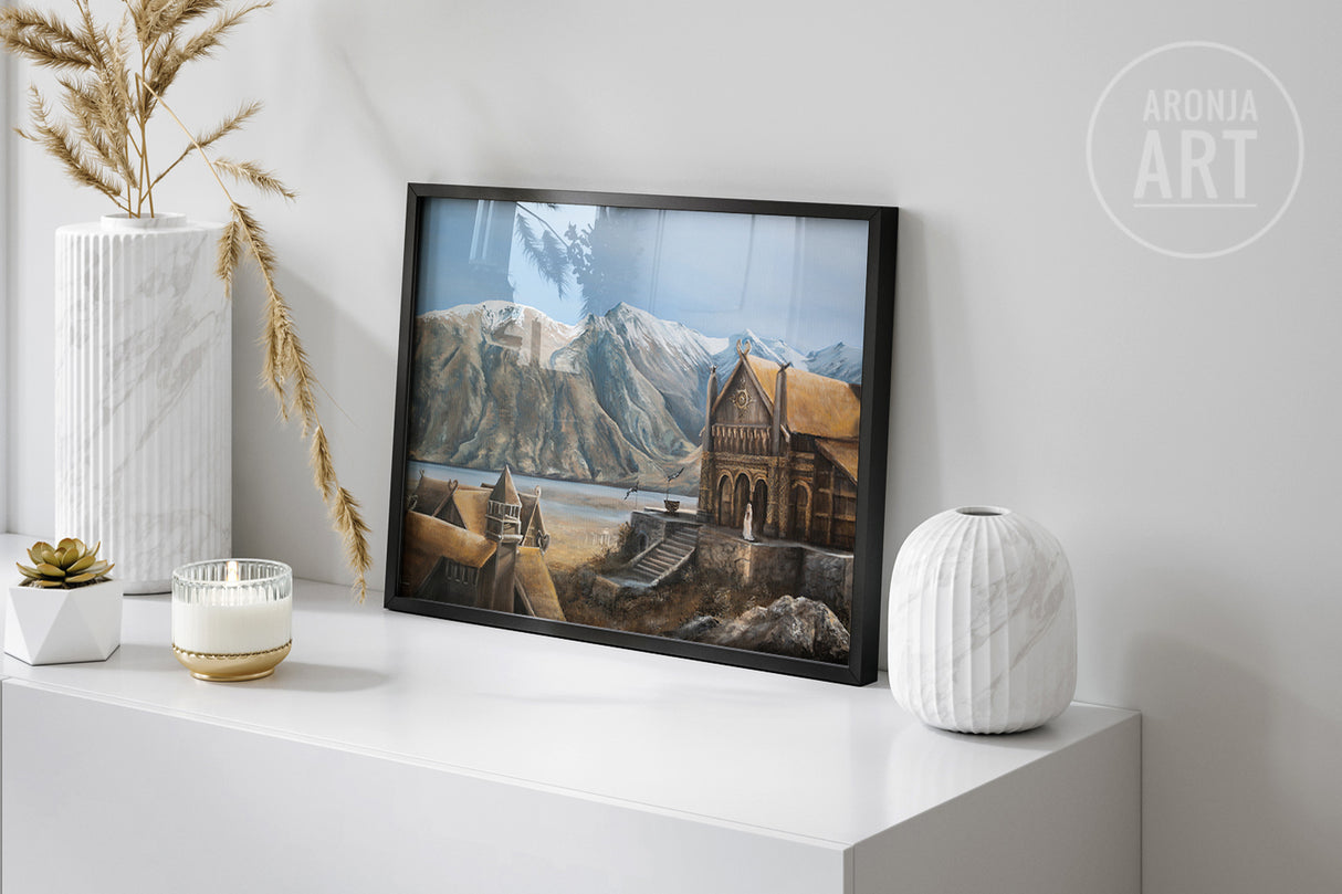 Framed print of a detailed traditional fantasy landscape featuring rustic hall architecture against mountainous terrain, titled The Golden Hall - (Print).