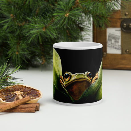 Leaf Me Sittin' - Mug by Aronja-Art black mug with cute frog artwork on a patio background